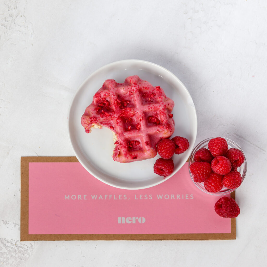 Single waffle on a small plate with raspberries