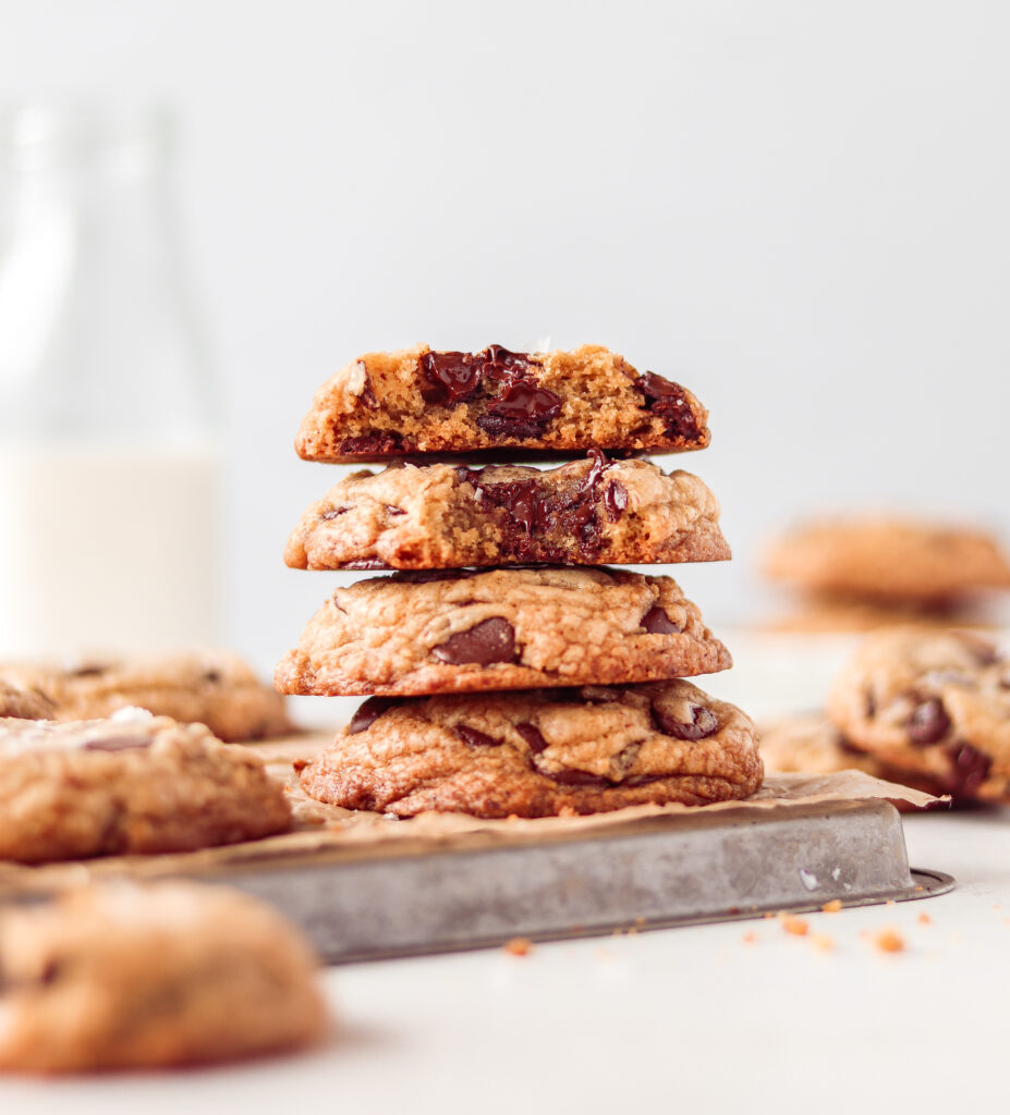 Chocolate chip cookies stacked on a baking pan