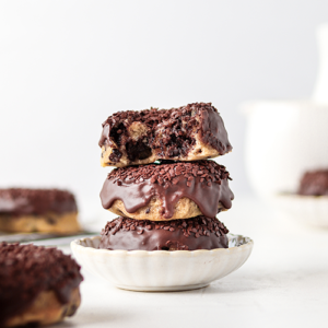 Baked choc chip donuts stacked on a small plate