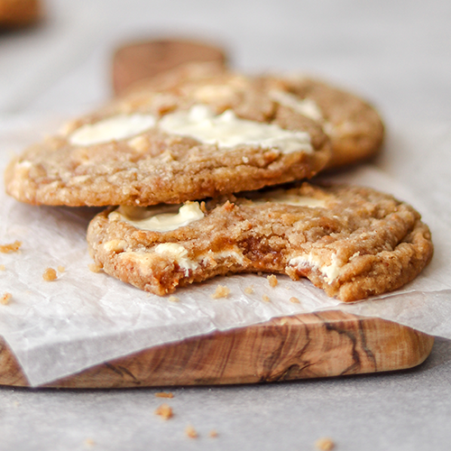 Toffee white chocolate chip cookies with a bite taken out of one