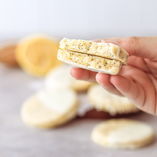 Lemon poppyseed cookie broken in half being held