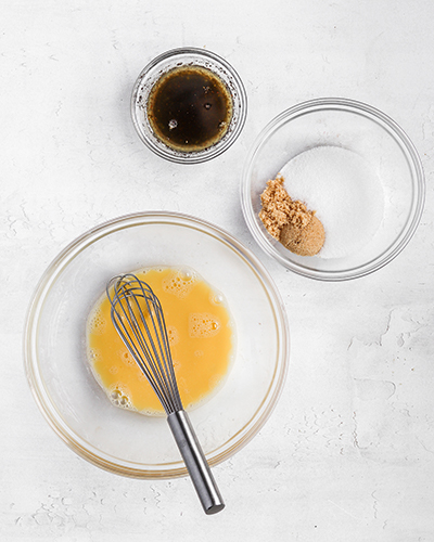 Melted butter, sugar, eggs in small bowls