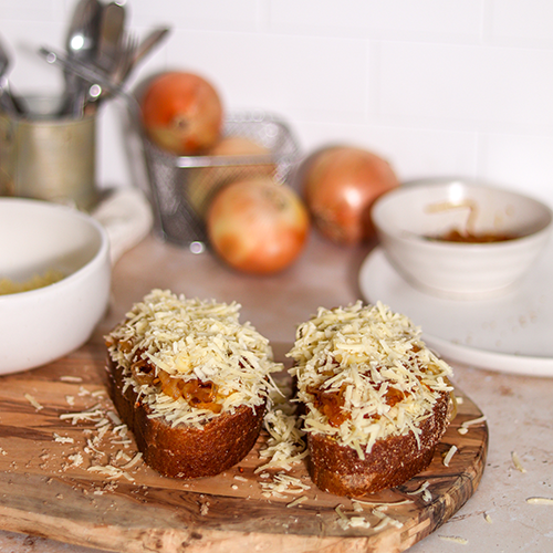 Caramelized onion grilled cheese halves before grilling