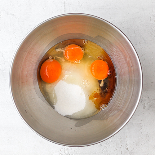 Eggs, white sugar and vanilla in a mixing bowl