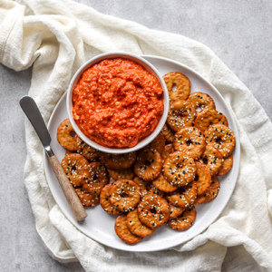 Red Pepper pesto dip with crackers on a plate