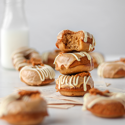 Baked Biscoff Donuts Stacked on top of each other, with donuts in the foreground and background