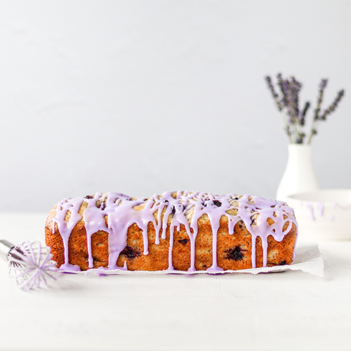 Side view of the pound cake, drizzled with a purple lavender glaze