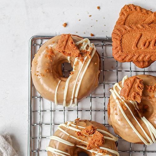 Close up of three baked biscoff donuts on a cooling rack