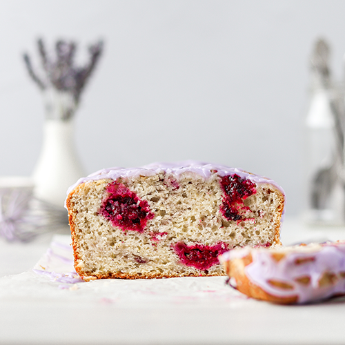 Inside the blackberry loaf cake, a slice is in the foreground