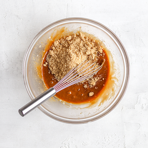 Brown sugar in a bowl with donut batter in it